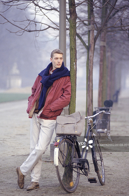 站在自行车旁的年轻男子图片素材