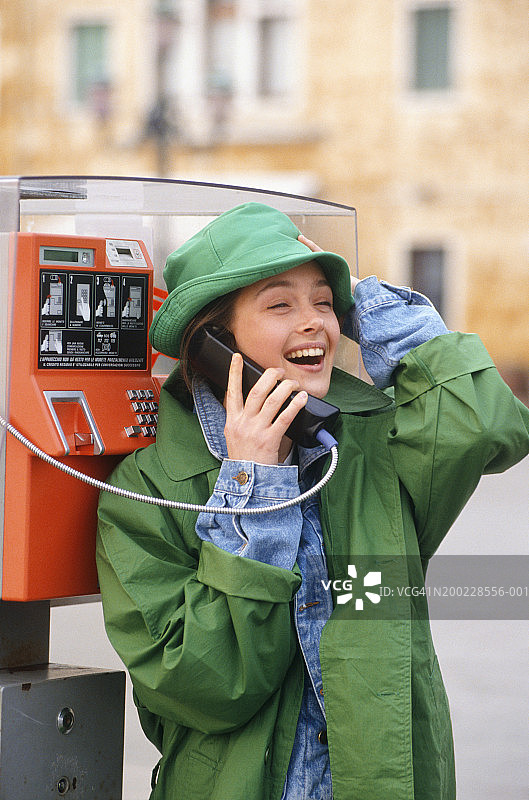 年轻女人在街头电话亭通话图片素材