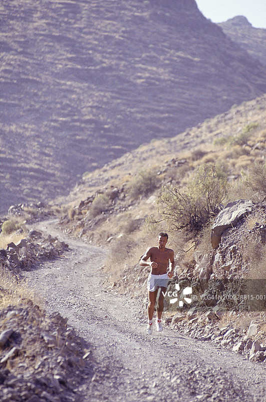 年轻男人在山路上奔跑图片素材