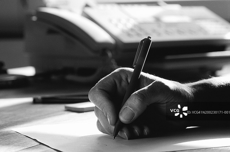手持笔书写的男人特写（黑白照片）图片素材