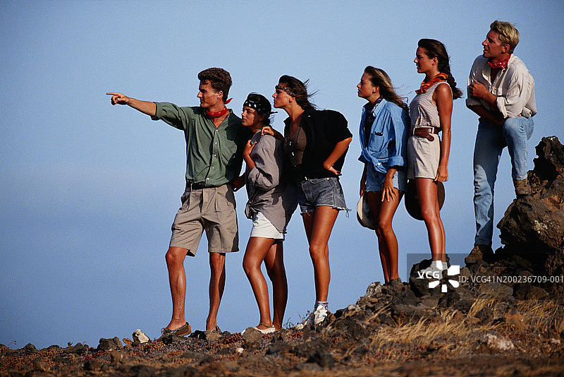 年轻人带领着一群人观看风景图片素材