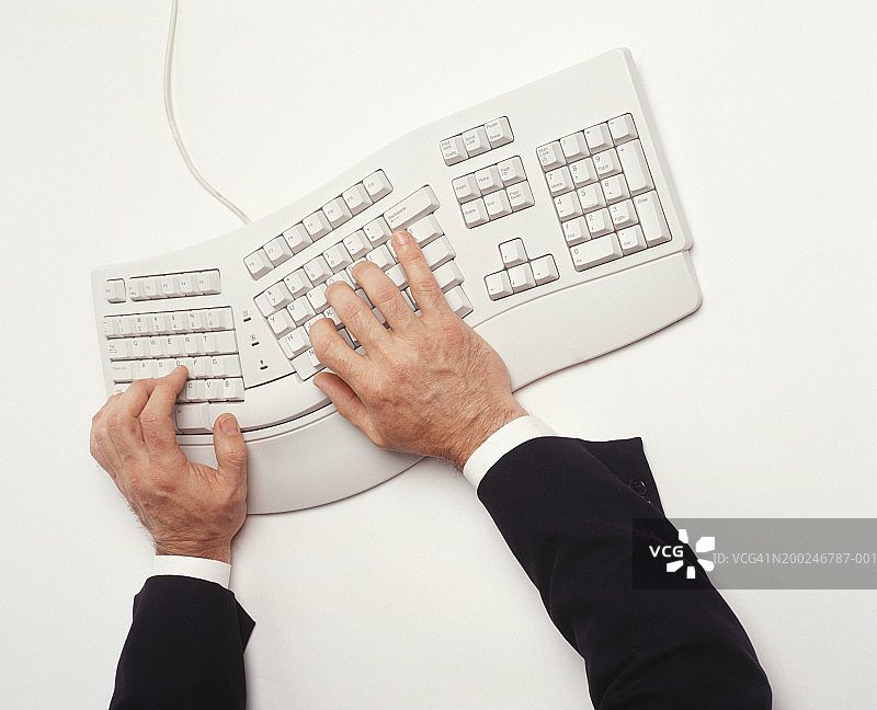 男人使用人体工学键盘打字，手部特写，高角度视图图片素材