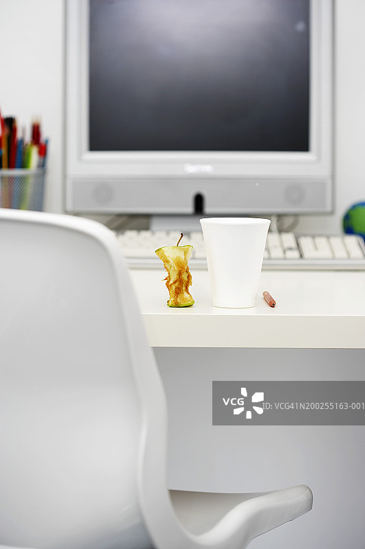 桌上一次性杯子旁的苹果核特写图片素材