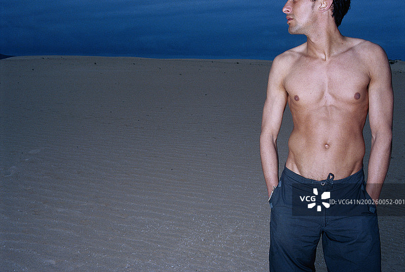 双手插在口袋里，回头看的赤膊男人图片素材