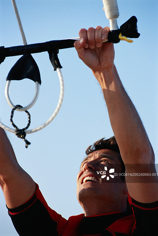 男人双手紧握绳索，抬头向上看图片素材