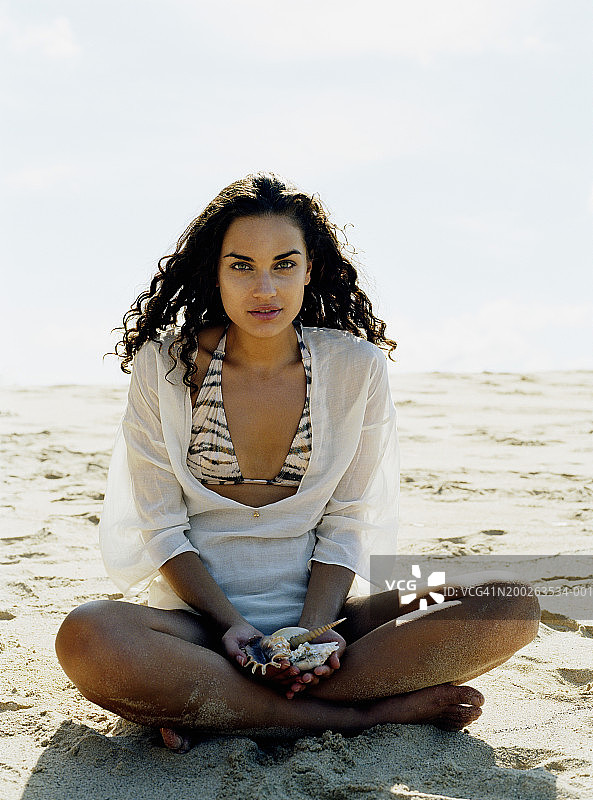 手拿贝壳的年轻女子图片素材