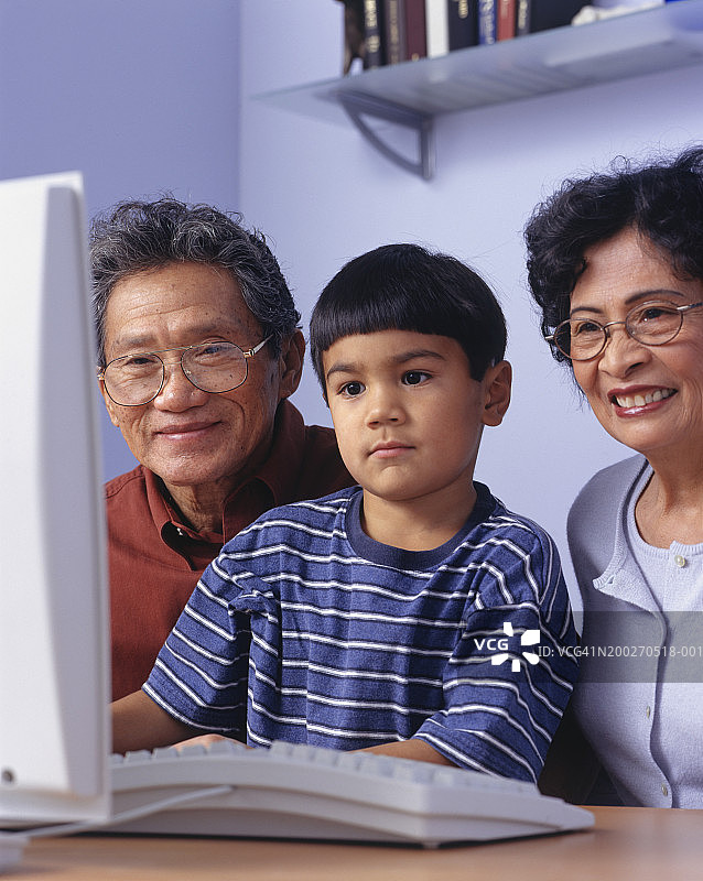 爷爷奶奶和孙子（4-5岁）坐在电脑前图片素材