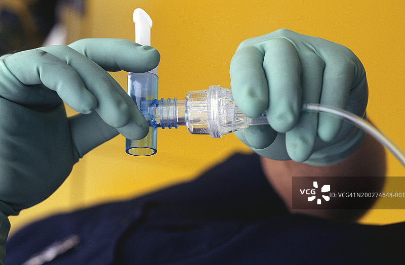 救护人员戴着橡胶手套组装氧气管，手部特写图片素材