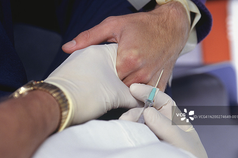 医护人员为病人进行静脉注射，手部特写图片素材