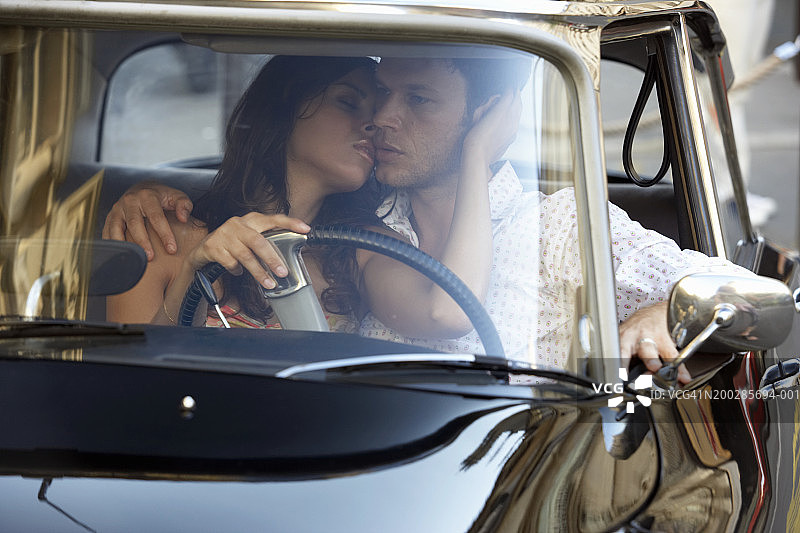 在车里的夫妇，女人拥抱驾驶座上的男人图片素材