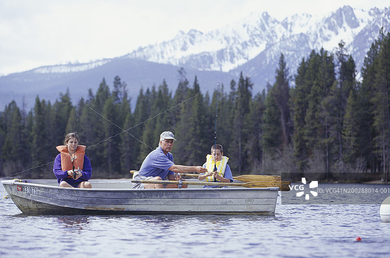 祖孙（10-11岁）（14-15岁）在山间湖泊的船上钓鱼图片素材