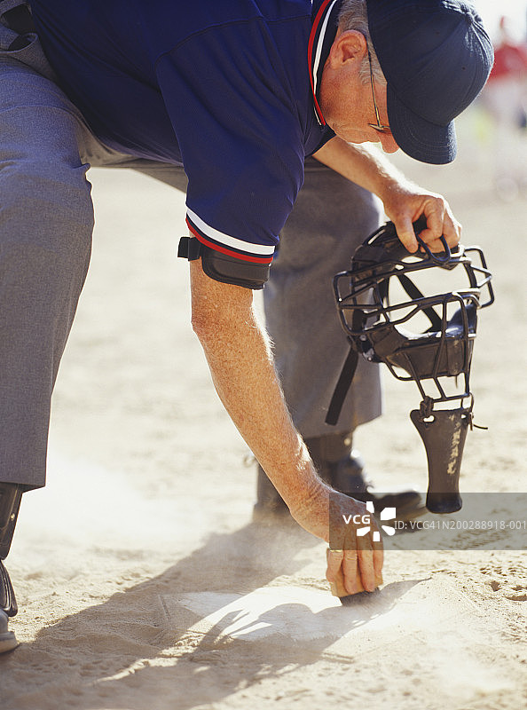 棒球场裁判清理本垒板图片素材