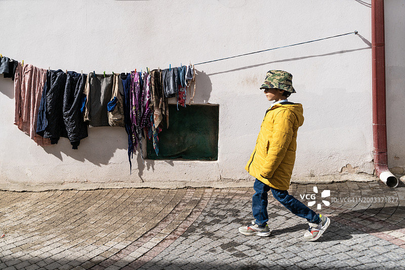 男孩戴着猎帽走在街上图片素材