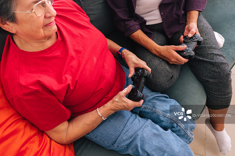 年长的母亲和女儿使用游戏手柄图片素材