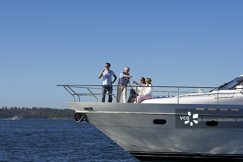 年长的夫妇和老年夫妇在游艇上喝香槟，笑容满面图片素材
