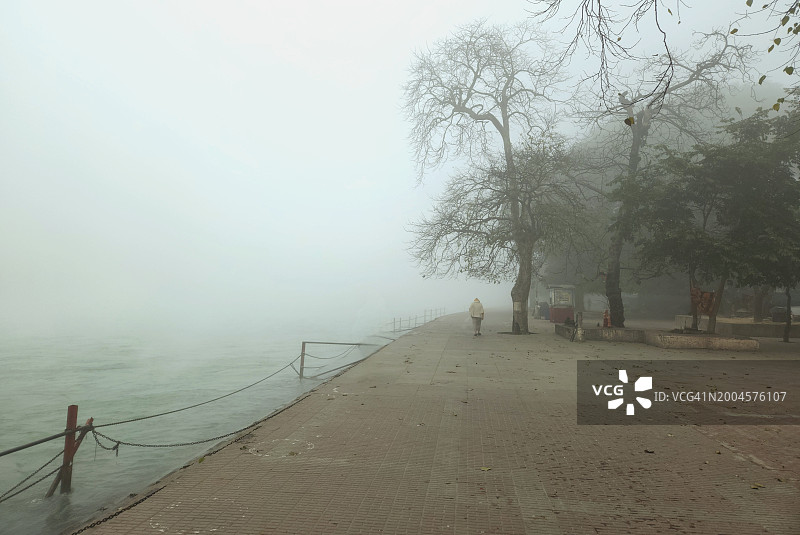 雾天城市湖畔的晨练者图片素材