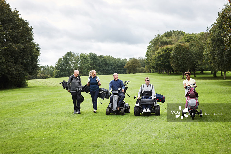 运动：高尔夫球场上的代步车和人群，进行高尔夫比赛。休闲、残疾人士以及男女球童在户外进行训练和练习图片素材