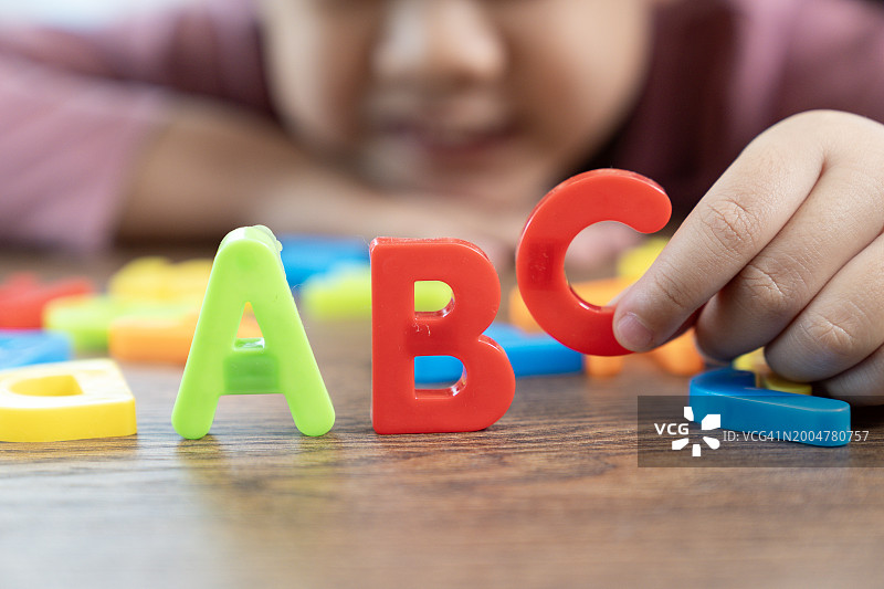 玩耍和学习英语字母的年轻女孩图片素材