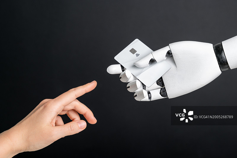 机器人与人类的手持银行卡图片素材