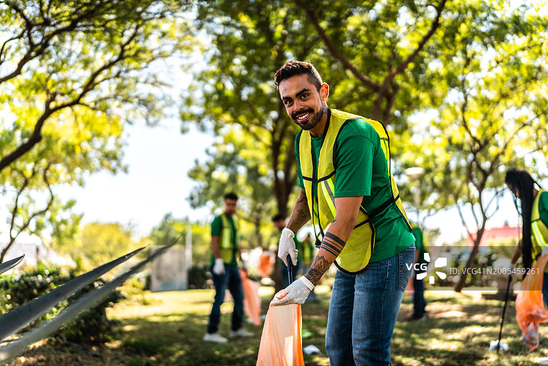 在公园收集垃圾的中年回收人员肖像图片素材