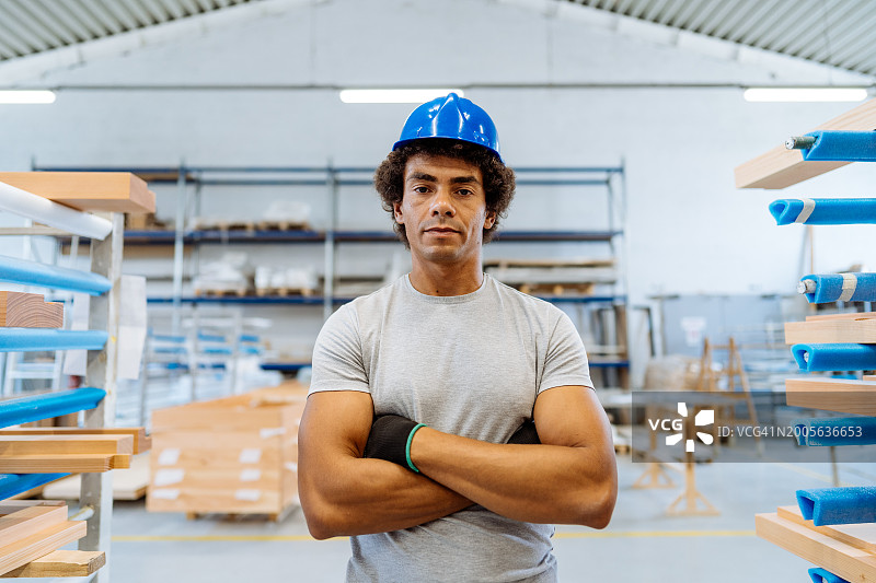 工厂里戴蓝色头盔的非裔美国蓝领工人肖像图片素材