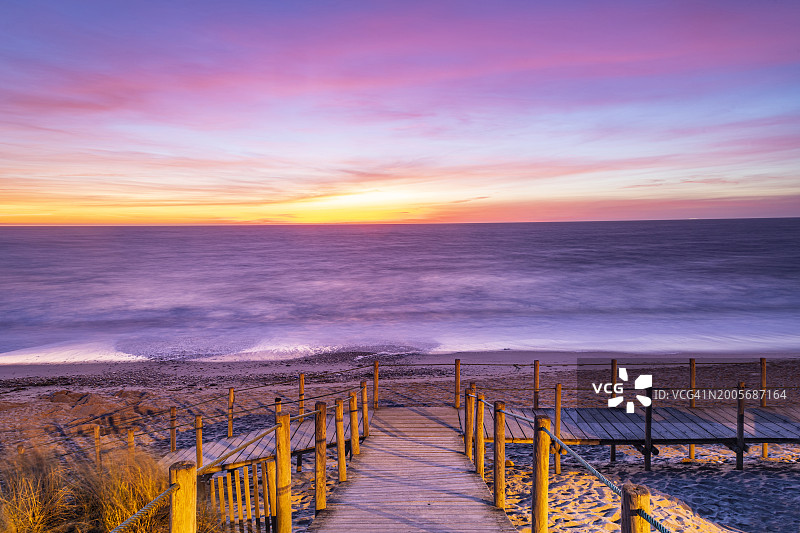 葡萄牙埃斯波森德：日落时分海边沙丘上的木制步道图片素材