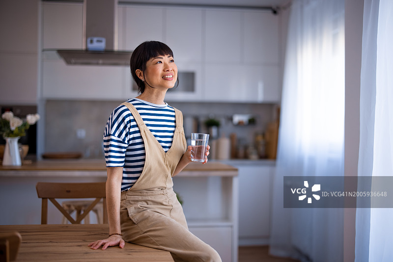 亚裔女子在家喝水图片素材