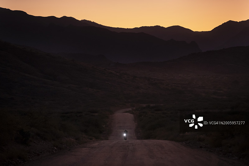 一名骑自行车的人骑着配备露营装备的砾石公路自行车，从弗拉格斯塔夫到菲尼克斯，途经塞多纳和亚利桑那州黑峡谷图片素材