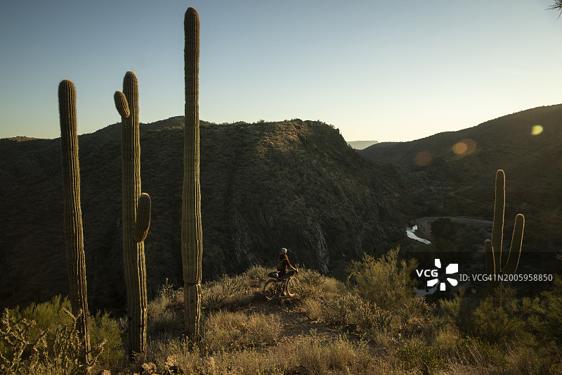 一名骑自行车的人骑着配备露营装备的砾石公路自行车，从弗拉格斯塔夫到菲尼克斯，途经塞多纳和亚利桑那州黑峡谷图片素材