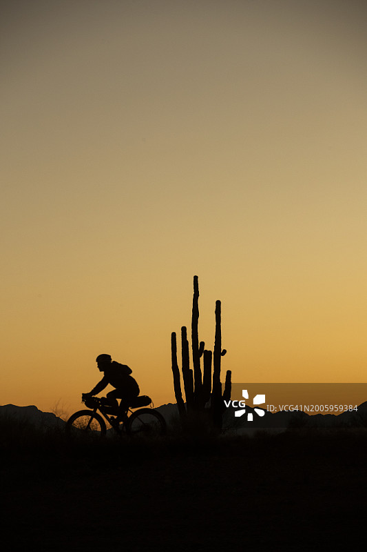 一名骑自行车的人骑着配备露营装备的砾石公路自行车，从弗拉格斯塔夫到菲尼克斯，途经塞多纳和亚利桑那州黑峡谷图片素材