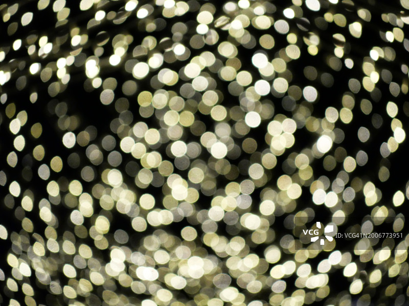 黑色背景上明亮的黄色散焦灯光。英国伦敦街道夜晚的童话灯光照片，自然光和色彩。图片素材