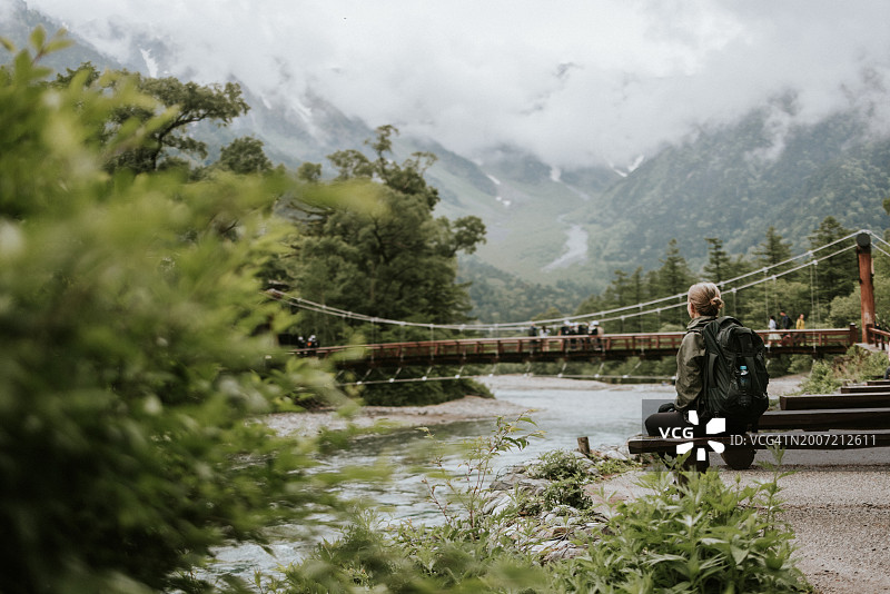 独自徒步的女性欣赏穗高岳旁的河童桥景色图片素材