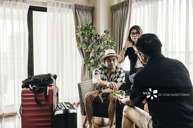 亚洲旅行团，男人在家打包旅行箱图片素材
