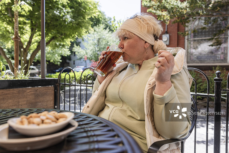 女人在街边咖啡馆喝啤酒图片素材