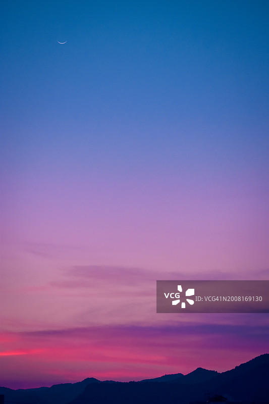 日落时群山映衬天空的剪影图片素材