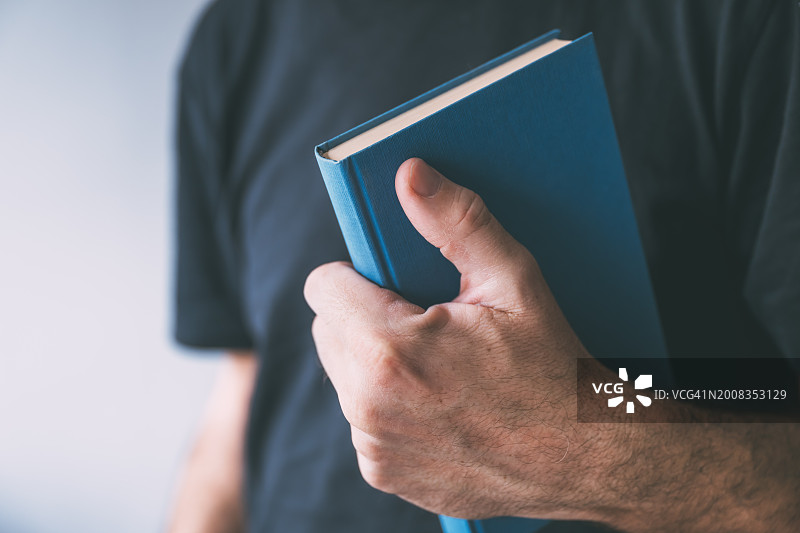 男人拿着书的身体中部照片图片素材