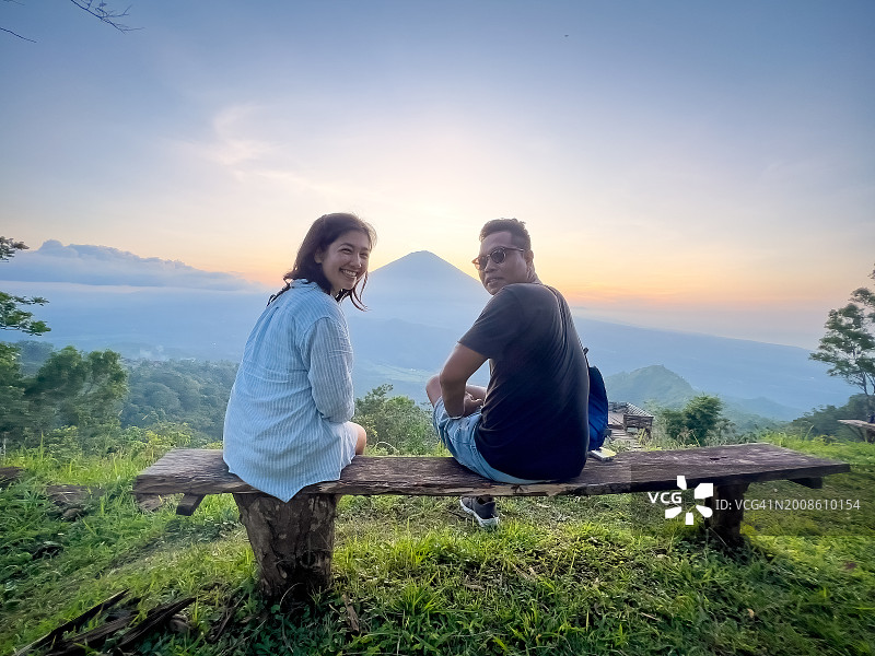 欧亚游客与印尼导游在山上观赏日落图片素材