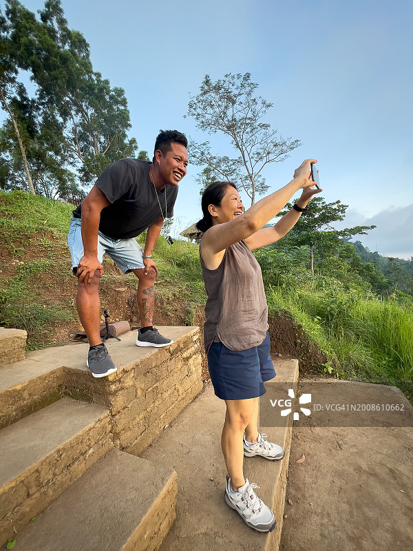 中国老年游客在观景点用智能手机拍照图片素材