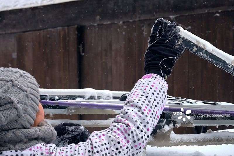 一家人滑雪旅行，从车顶行李架上取出滑雪板图片素材