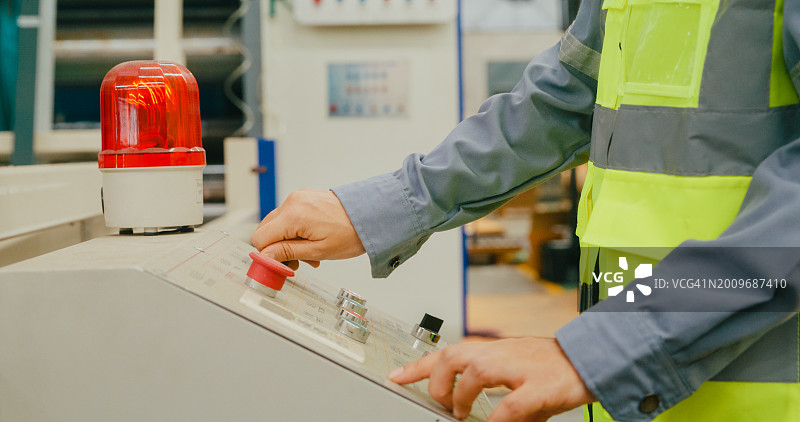 亚洲女工程师在制造工厂操作机器键盘特写，生产车间工作概念图片素材