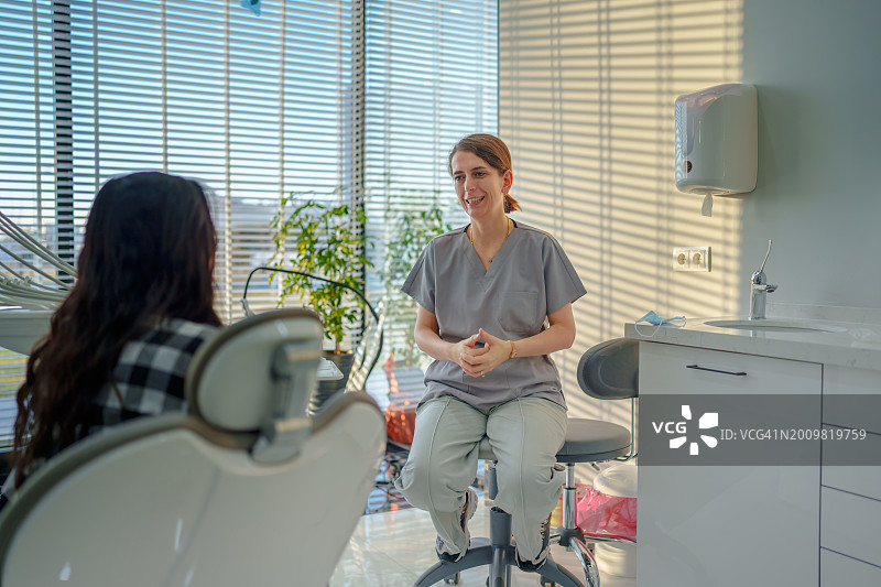 系列：女牙医为躺在牙椅上的女患者进行种植治疗图片素材