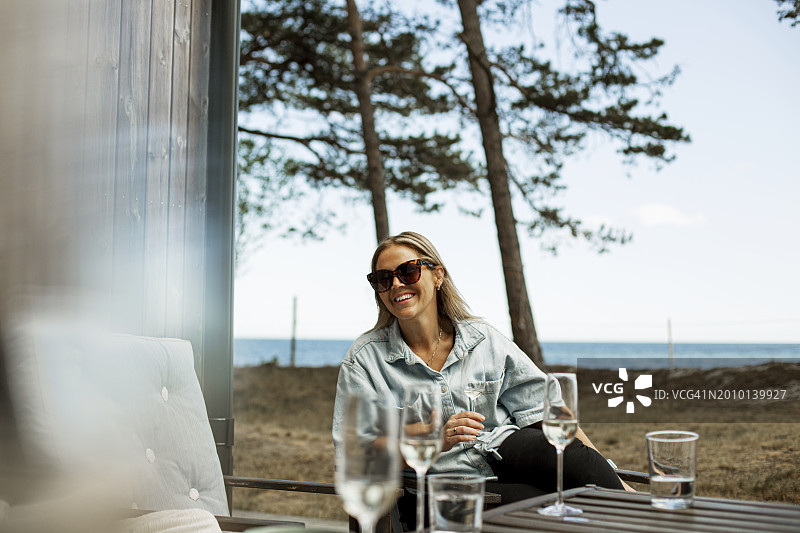 微笑女人周末靠海喝香槟图片素材