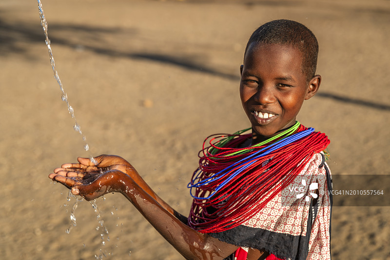 非洲年轻女孩在东非草原上喝水图片素材