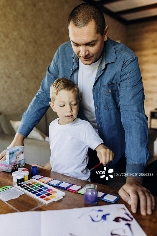 父子在家用水彩画画图片素材