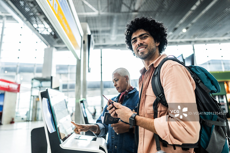 中年男人在机场使用自助值机设备图片素材
