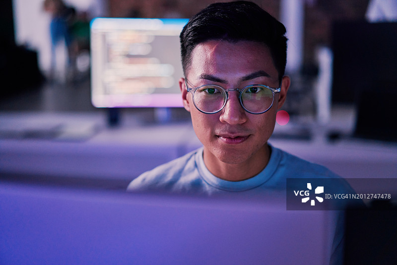 程序员在夜晚的办公室进行软件开发、网络安全或数据库维护图片素材