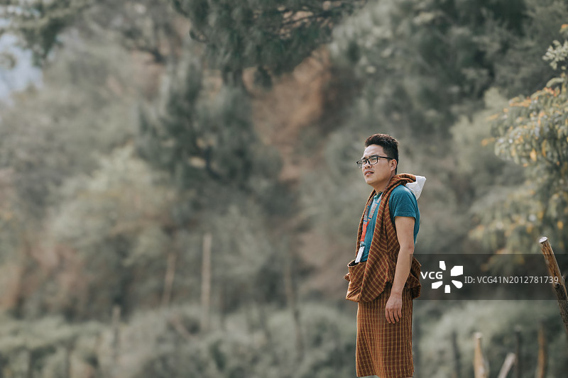 站在乡村眺望远方的不丹男子图片素材