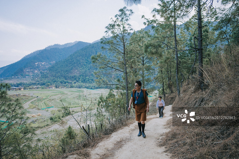 不丹导游带领亚洲女性游客在不丹徒步旅行图片素材