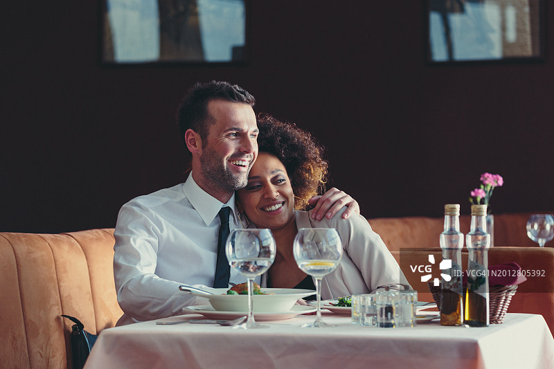 在餐厅享用晚餐的快乐情侣图片素材