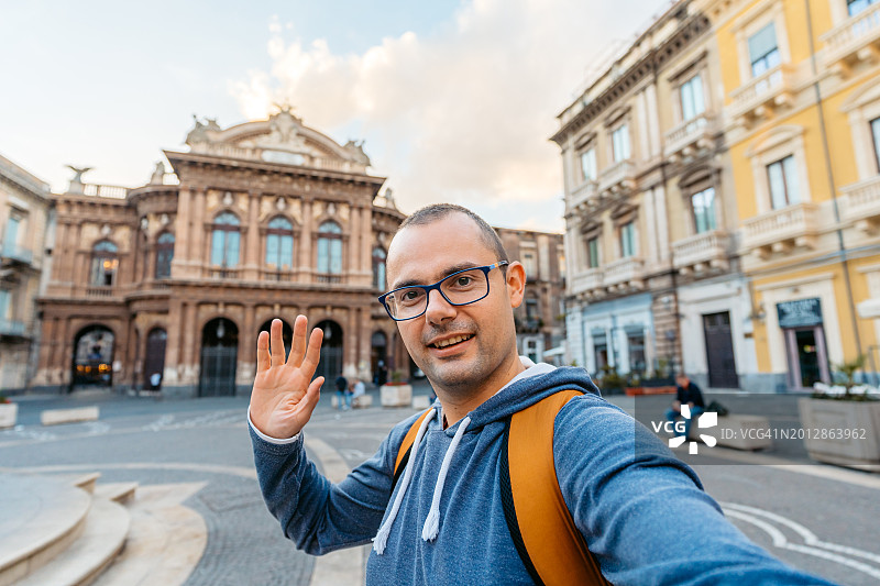 年轻男人在卡塔尼亚贝里尼广场视频通话图片素材